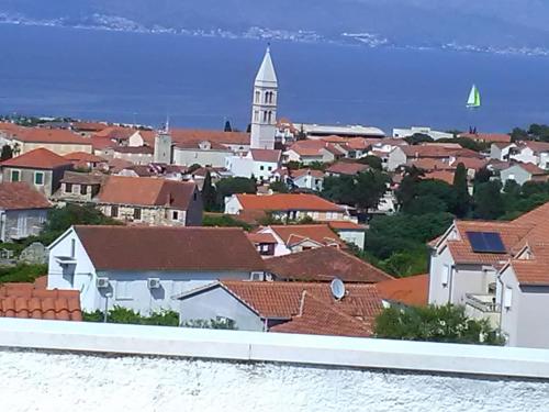 a view of a town with a church and roofs at Apartmani Vesna Supetar in Supetar