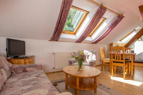 a living room with a couch and a table with flowers on it at Landhaus Bergidyll in Bärenstein