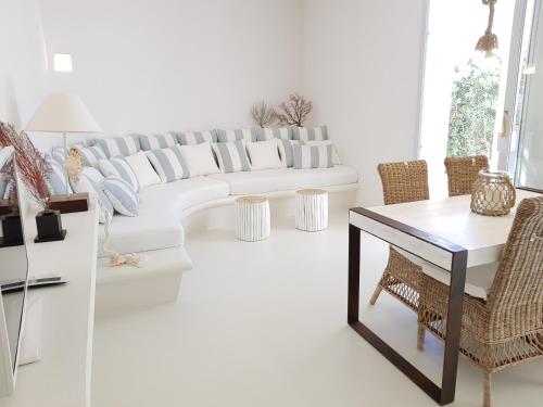 a living room with a white couch and chairs at Casa Mirella in Favignana