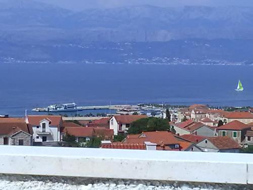 a view of a town with a sail boat in the water at Apartmani Vesna Supetar in Supetar