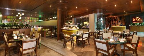 a restaurant with tables and chairs and a bar at Park Regis Lotus Hotel in Manama
