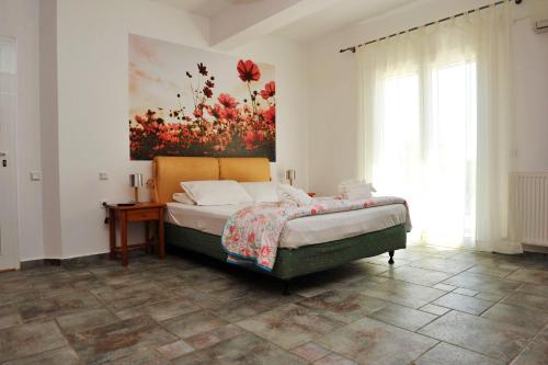 a bedroom with a bed and a painting on the wall at Nina Areti in Skiathos