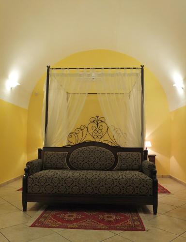 a couch sitting in a room with a curtain at Villa Musica in Sannicola