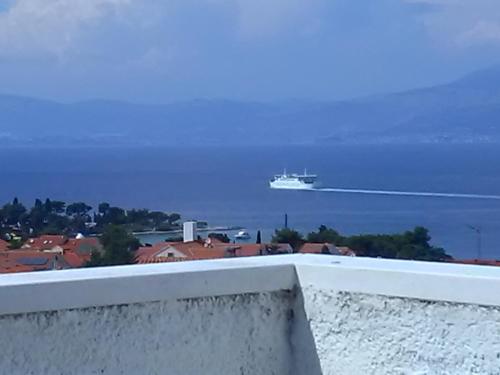 a cruise ship in the water with a city at Apartmani Vesna Supetar in Supetar