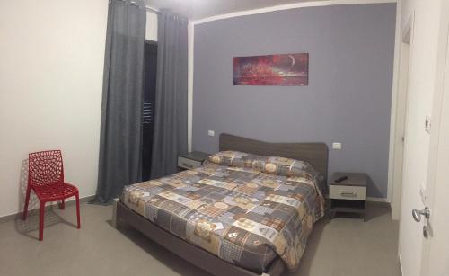 a bedroom with a bed and a red chair at B&B Casa Giorgia in Campobasso
