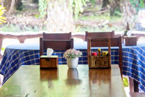 a wooden table with two chairs and a table with a blue table cloth at Khao Sok Palmview Resort in Khao Sok