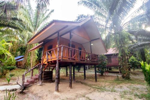 a small house on stilts in front of some palm trees at Khao Sok Palmview Resort in Khao Sok
