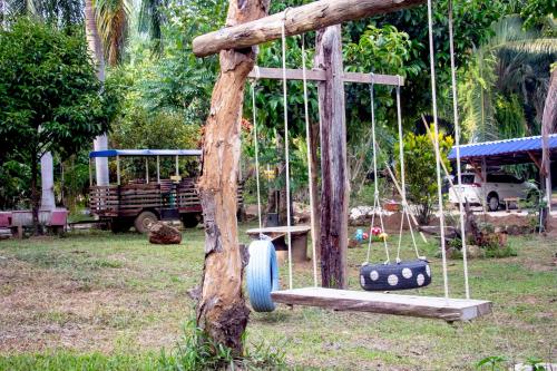 a swing in a yard with a tree at Khao Sok Palmview Resort in Khao Sok