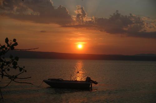 a boat sitting in the water at sunset at La Piazzetta in Bolsena
