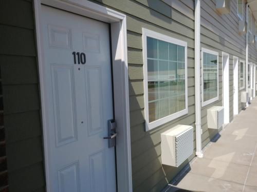 a white door with the number on it next to a building at Boarders Inn & Suites by Cobblestone Hotels - Broken Bow in Broken Bow