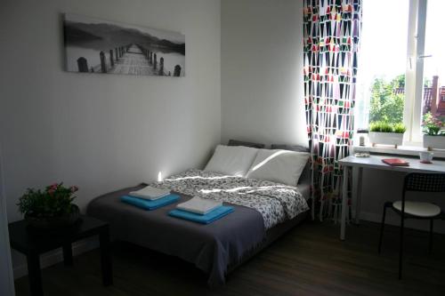 Baltica Apartament في غدانسك: غرفة نوم صغيرة مع سرير ومكتب