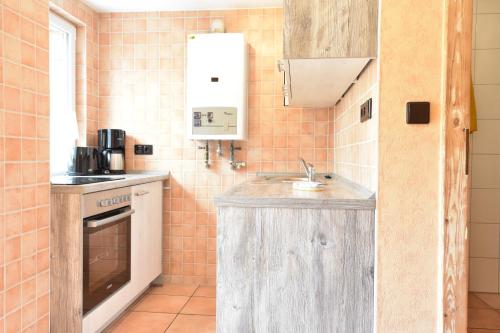 a small kitchen with a sink and an oven at Haus Seepferdchen in Graal-Müritz