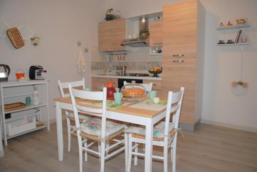 Una cocina con una mesa y sillas en una habitación. en Il Cancelletto, en Siracusa