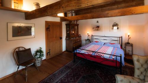 a bedroom with a bed and a chair at Biohof Hausberg in Egglham