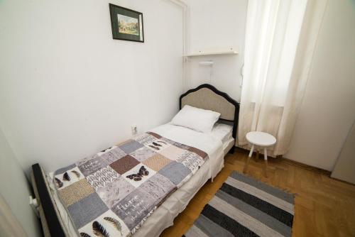 ein kleines Schlafzimmer mit einem Bett und einem Tisch in der Unterkunft Apartment Resavska in Belgrad
