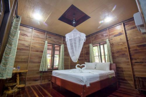 a bedroom with a bed and a chandelier at Khao Sok Palmview Resort in Khao Sok