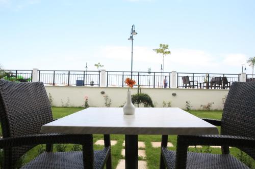a table with two chairs and a vase with a flower on it at Makedos Sea View in Nea Vrasna