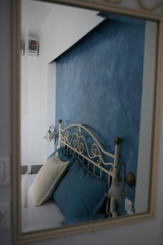 a mirror reflection of a bed with a blue wall at Makedos Sea View in Nea Vrasna