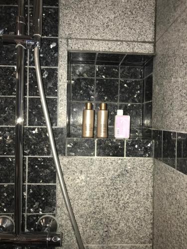 a shower with two gold cylinders in a bathroom at Hinna Garden in Stavanger