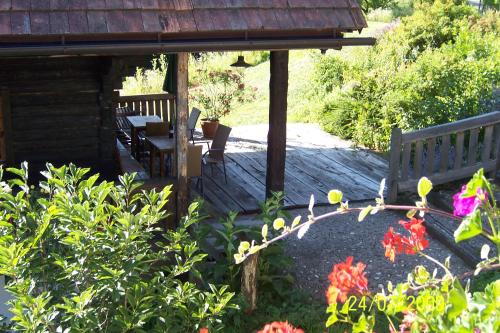 a wooden deck with a bench and some flowers at Weingut-Gästezimmer Pongratz in Gamlitz