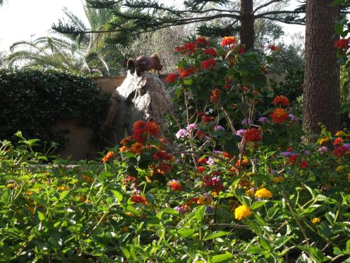 a statue of a cow in a garden with flowers at Villa Musica in Sannicola