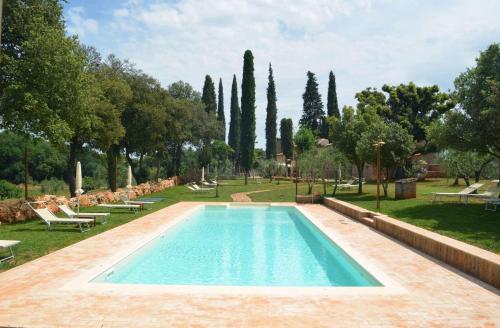 una piscina en un parque con árboles en La Tenuta di Castelvecchio, en San Gimignano