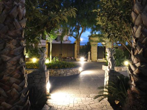 a stone archway with lights in a courtyard at night at Villa Musica in Sannicola