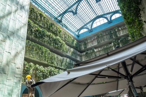 a building with a green wall with an umbrella at Hotel San Francisco Leon in León