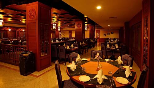 a dining room with tables and chairs in a restaurant at JP Chennai Hotel in Chennai