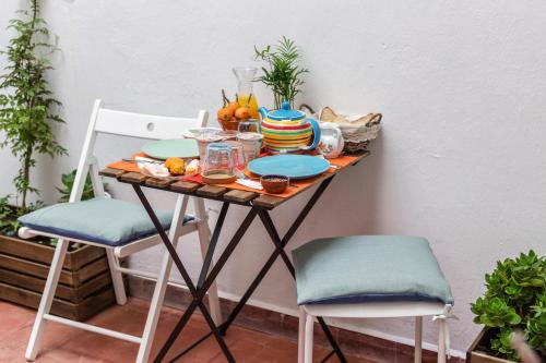 a table with plates of food on it with two chairs at Casas da Formosa - Downtown Alegria in Tavira