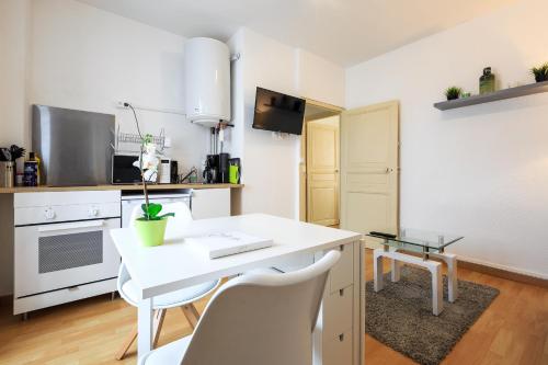 - une cuisine blanche avec un bureau et des chaises blancs dans l'établissement Le duc de Vichy, à Vichy