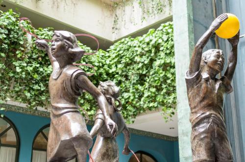 a statue of two women playing with a ball at Hotel San Francisco Leon in León