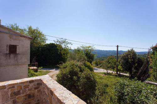 a stone wall next to a building and a road at Villa Franz Krbune in Potpićan