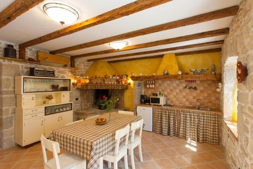 a kitchen with a table with chairs and a kitchen with a counter at Villa Franz Krbune in Potpićan