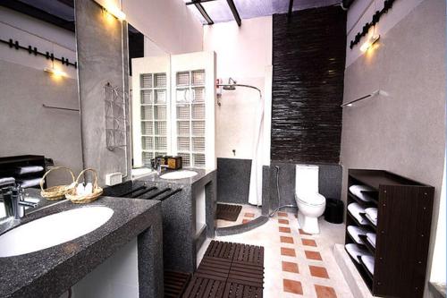 a large bathroom with a sink and a toilet at Pangrujee Resort in Nakhon Ratchasima