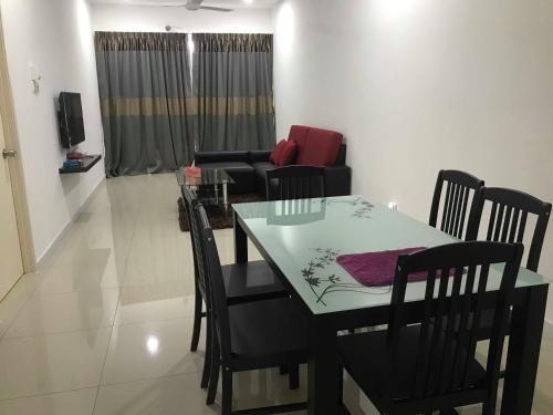 a dining room and living room with a table and chairs at Mr.J Homestay in Taiping