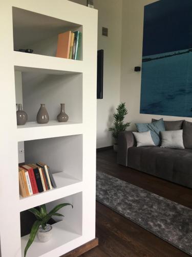 a living room with a couch and book shelves at Balkon Apartman Horváth Ház Balatonfüred in Balatonfüred