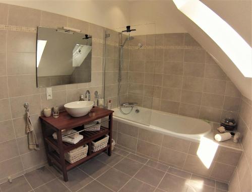 La salle de bains est pourvue d'un lavabo et d'une baignoire. dans l'établissement La Closeraie, à Noyers-sur-Cher