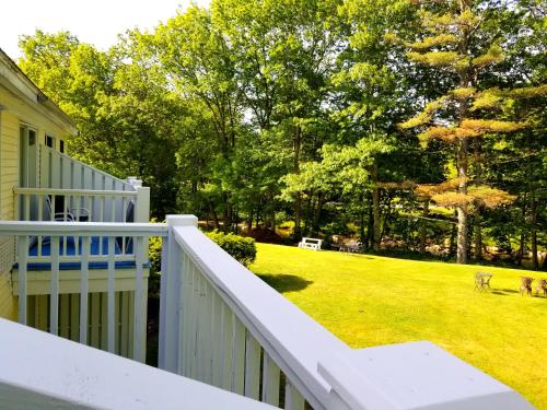 a porch with a white railing and a yard at The Lodge at Jackson Village in Jackson