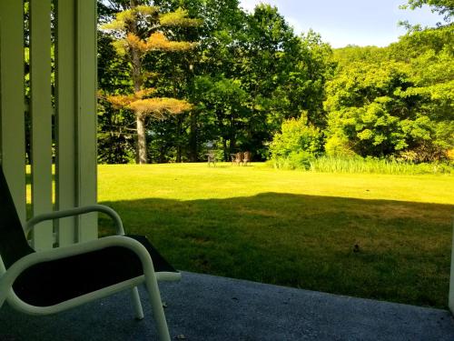 a chair sitting on a porch with a view of a field at The Lodge at Jackson Village in Jackson