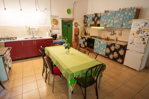 a kitchen with a table, chairs and a refrigerator at Mi Casa es Tu Casa - Shkodra Backpackers Hostel in Shkodër