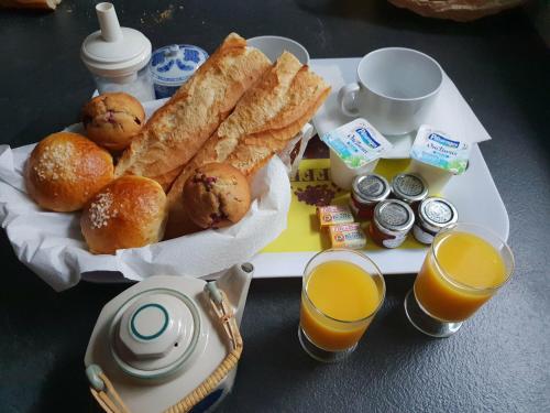 - un plateau de petit-déjeuner composé de pain et de jus d'orange dans l'établissement Studio Le Lavandou, au Lavandou