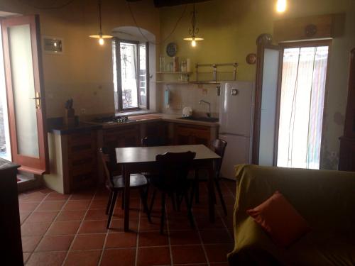 eine Küche mit einem Tisch und einem Kühlschrank in der Unterkunft COOL SUMMER ReTREAT in Susak
