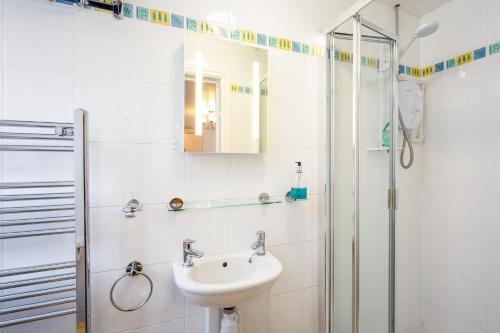 a white bathroom with a sink and a shower at Stratford Studios in Stratford-upon-Avon