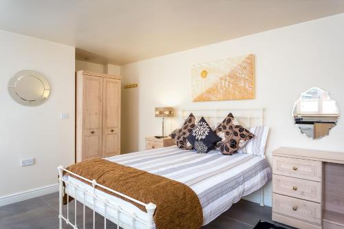 a bedroom with a white bed with pillows at Stratford Studios in Stratford-upon-Avon