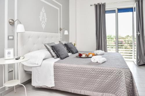 ein weißes Schlafzimmer mit einem Bett und einem Tablett mit Obst darauf in der Unterkunft Insula House in Ercolano