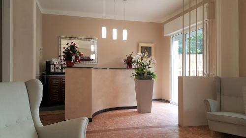 a lobby with a counter with flowers on it at La locanda di Gioele in Lido di Camaiore