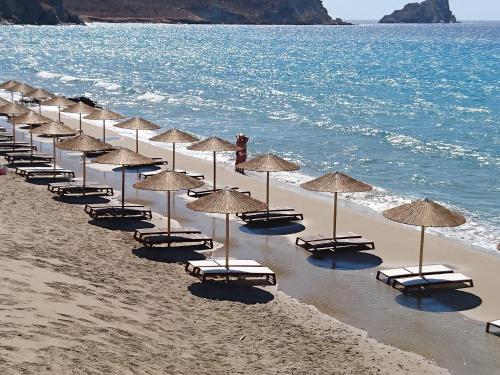 a row of chairs and umbrellas on a beach at Villa Kalliopi ΙnCreteble Cretan Resindences Collection in Xerokampos