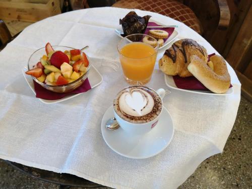 a table with a cup of coffee and a bowl of fruit at Torrione Trento in Trento