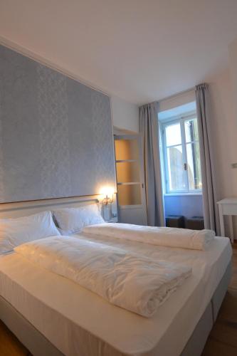 a large white bed in a bedroom with a window at Torrione Trento in Trento